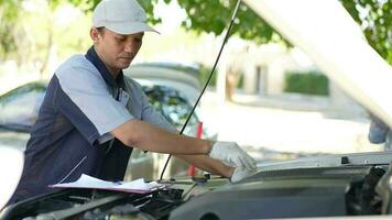 auto mecânico verificação e manutenção para cliente a motor uma veículo carro de capuz e mestres inspetor substitui a estragado partes dentro carro enquanto verificação a trabalhos do a carro. serviço, reparar conceito video