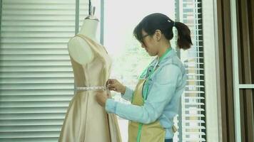 ásia mulher costureira moda desenhador medindo Tamanho do manequim dentro showroom. conceito do costura e moda video