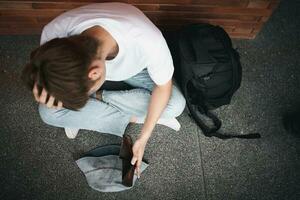 A desperate Asian opening wallet and looks at his empty wallet. Unhappy Asian people with no cash in their purses, bankrupt economic financial , Poverty in retirement, and unemployment concept. photo