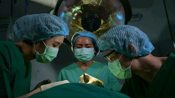 Low Angle Shot of Professional surgeons team performing surgery in operating room, surgeon, Assistants, and Nurses Performing Surgery on a Patient, health care cancer and disease treatment concept video