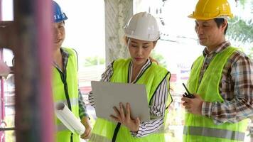 Group of Asian engineer or Young Female Architect put on a helmet for safety and talk with a contractor on a construction building factory project, Concept of Teamwork, Leadership concept. video
