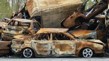 un lote de quemado despedido carros en el estacionamiento lote, el Consecuencias de el invasión de Ucrania. guerra en Ucrania. cementerio de destruido carros de civiles quien intentó a evacuar desde el guerra zona. foto