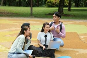 joven asiático malayo chino hombre mujer al aire libre parque libro archivo carpeta ordenador portátil computadora teléfono sentar estar estudiar mezclarse foto