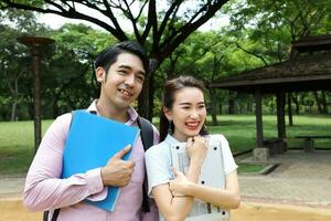 young asian malay chinese man woman outdoor park walk stand study talk discuss laptop file book backpack pose happy mingle look forward photo