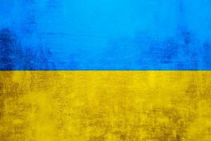 The wall is in the colors of the Ukrainian national flag - blue and yellow. Abstract texture background of concrete stone wall. Ukrainian flag on a grunge wall in connection with the war with Russia. photo