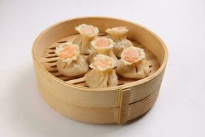 Prawn shrimp shaomai dim sum dumpling in bamboo steamer on white background photo