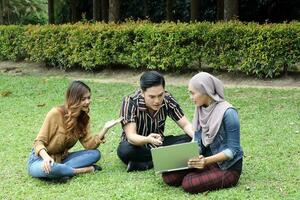 joven asiático diferente étnico malayo chino hombre mujer actividad estilo de vida estudiante educando trabajo negocio sentar en césped discutir foto