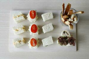 Small mini sandwich platter chicken tuna cheese egg on wooden platter photo