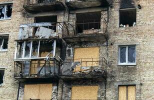 Burnt apartments in a multi-storey residential building, the consequences of the war in Ukraine. Buildings damaged by shells. A bombed-out apartment building after an airstrike. photo