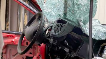 roto arrugado rojo coche después un grave accidente con un sesgado cuerpo, después un poderoso explotar. accidente en el calle, dañado coche después un colisión en el ciudad. auto accidente. roto coche en el calle. foto