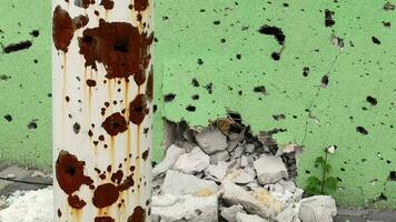 gaten van kogels en granaatscherven in de muur Aan de voorkant lijn. littekens van oorlog. beton muur van een woon- gebouw met kuilen en gaten van geweervuur. gevolgen van de oorlog in Oekraïne. video