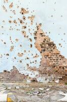 el pared de un edificio abollado por cohete fragmentos en un guerra zona. sin cáscara pared. fachada de un bombardeado edificio. armado conflicto en Ucrania. dañar a el casa como un resultado de artillería bombardeo. foto