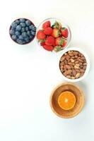 Blueberry Strawberry Herb Spice Almond Cashew Nut Mandarin Orange in bowl on white background photo