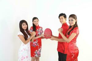 South East Asian young Malay Chinese Indian man woman wearing traditional chinse cheongsam dress on white background shop exchange gift orange greetings share racial unity harmony hand fan photo