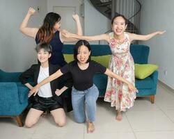 Young southeast asian woman group dancing enjoying fun party in living room photo