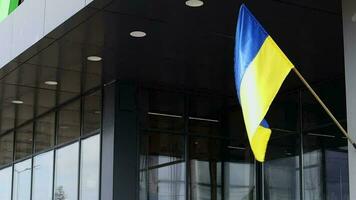 The national flag of Ukraine flutters in the wind on a flagpole, on a building. Blue and yellow colors on the Ukrainian flag. Flag of Ukraine on the facade of the government building. video