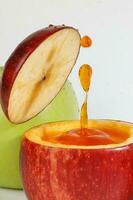 Red Apple real juice splash in fresh half cut hollow cup fruit photo