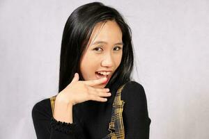 joven atractivo Sureste asiático mujer posando facial expresión sonrisa preguntarse Bienvenido burlón foto