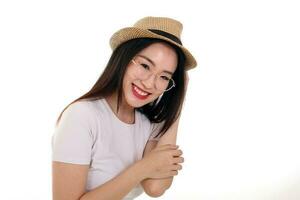 Beautiful young south east Asian woman wearing eyewear golden frame glasses hat pose fashion style white background look around copy text space hands on hat photo