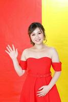 asiático mujer moderno rojo vestir en amarillo rojo multicolor papel antecedentes ondulación mano foto
