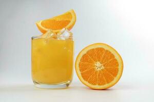 Fresh yellow orange juice in glass with orange slice and ice cube on white background photo