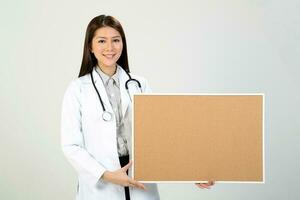 Young Asian female doctor wearing apron stethoscope holding a blank sign board photo