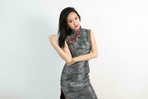 Beautiful young elegant southeast Asian woman wearing modern Chinese cheongsam dress pose smile look photo