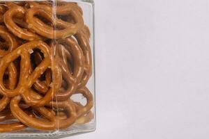 Pretzel cracker in a glass jar on white background photo