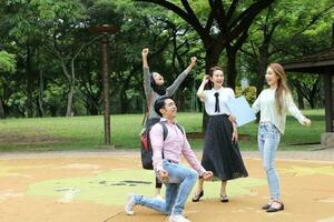 joven asiático malayo chino hombre mujer al aire libre parque libro archivo carpeta ordenador portátil computadora teléfono sentar estar estudiar mezclarse foto