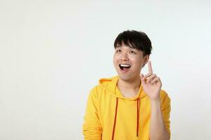 Young good looking Asian chinese malay man pose face body expression mode emotion on white background thinking idea finger point up photo