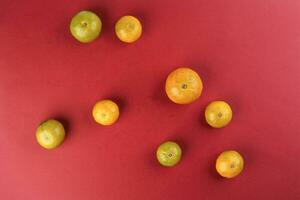 small yellow green mandarin orange on red colour paper background copy space for text photo