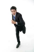 Southeast Asian young office business man wearing suit running at camera on white studio background photo