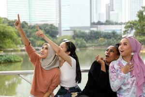 Group of woman Malay Chinese Indian Asian Malaysian outdoor green park lake nature surprised finger point up gesture photo