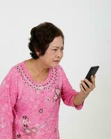 Elderly asian Chinese female on white background read text massage on phone serous look close photo