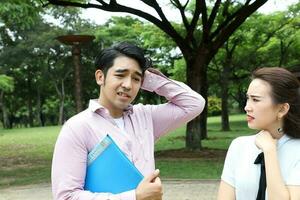 joven asiático malayo chino hombre mujer al aire libre parque libro archivo carpeta ordenador portátil computadora teléfono sentar estar estudiar mezclarse foto