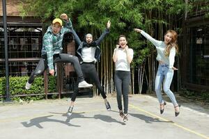 Young asian malay chinese man woman outdoor jump up in air joy happy success student friend photo