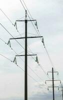 High voltage electrical tower against the sky. High voltage power lines. Electrical distribution station. The passage of the overhead line wire supports carrying light and heat into the house. photo