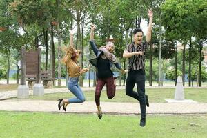 Young Asian Malay man woman outdoor green park joy happy jump in the air photo