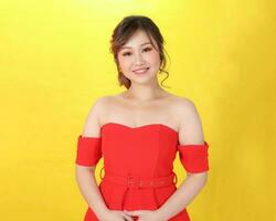 Asian woman modern red dress on yellow red multicolour paper background waving hand photo