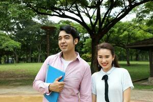 young asian malay chinese man woman outdoor park walk stand study talk discuss laptop file book backpack pose happy mingle look forward photo