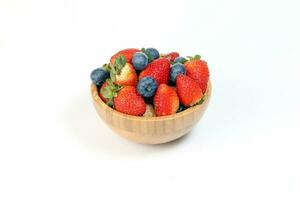 Strawberry blueberry in wooden bowl on white background photo