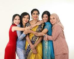 outh east Asian Malay Chinese Indian race ethnic origin woman wearing dress costume baju kurung cheongsam samfu kebaya Sharee multiracial community on white background happy smile hug togetherness photo