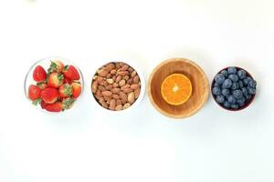 Blueberry Strawberry Herb Spice Almond Cashew Nut Mandarin Orange in bowl on white background photo