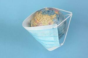 globe planet world map earth wearing face mask on blue background photo