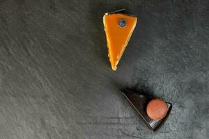 Chocolate cream caramel macaroon cake slice on black slate marble photo