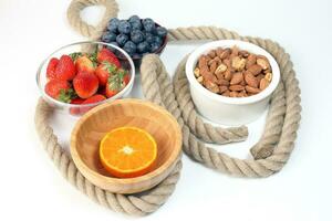 Blueberry Strawberry Herb Spice Almond Cashew Nut Mandarin Orange in bowl on white background photo