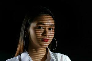 joven hermosa moderno malayo mujer antecedentes con gobo emitir sombra en cara foto