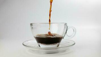 dark Coffee poring dripping splash shadow liquid swirl in glass cup saucer on white background stop motion photo