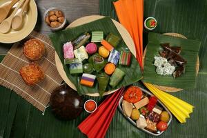 Varity Malaysian south east Asian nyonya kuih sweet desert sago tilam pulut terkan inti koci bongkus koo lapis dodol onde onde on green banana leaf wooden plate photo