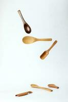 Wooden spoon utensils on white background elevated flying floating photo